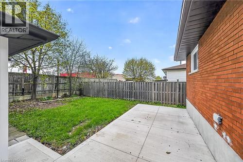 Private backyard featuring a concrete patio, a grass lawn area, and a wood privacy fence - 74 Victor Boulevard, Hamilton, ON - Outdoor