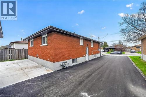 Red brick exterior with white trim windows and a black shingle roof - 74 Victor Boulevard, Hamilton, ON - Outdoor With Exterior
