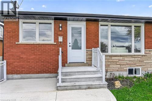 Brick and stone exterior featuring white frame windows - 74 Victor Boulevard, Hamilton, ON - Outdoor With Exterior