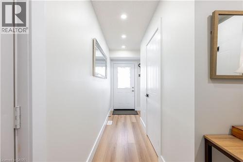 Bright entryway featuring wood-finish flooring, recessed ceiling lighting, a white panel door, and white baseboards - 185 Highland Crescent Unit# 2, Kitchener, ON - Indoor Photo Showing Other Room