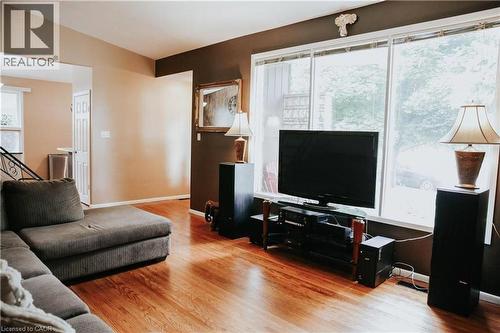 Open living area featuring wood-finish flooring, large windows, and an arched entry - 1 Vera Court, Hamilton, ON - Indoor Photo Showing Living Room