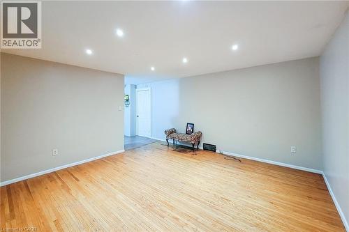 Spacious room featuring hardwood flooring, recessed lighting, neutral wall tones, and white trim - 1 Vera Court, Hamilton, ON - Indoor
