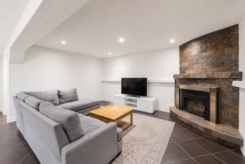 Basement - 14 Rue Dragon, Kirkland, QC - Indoor Photo Showing Living Room With Fireplace
