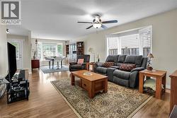 Living room with light wood-type flooring and ceiling fan - 