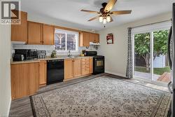 Kitchen with black appliances, decorative backsplash, healthy amount of natural light, and wood finished floors - 