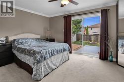 Primary Bedroom featuring access to outside, crown molding, carpet, and a ceiling fan - 
