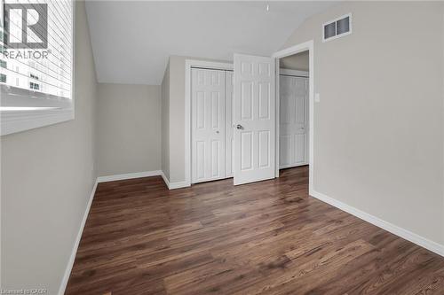 Second floor bedroom with vaulted ceiling, dark wood-style floors, and a closet - 4432 Dennis Avenue, Beamsville, ON - Indoor Photo Showing Other Room