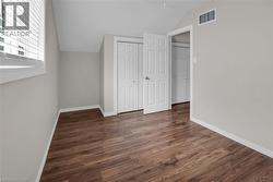 Second floor bedroom with vaulted ceiling, dark wood-style floors, and a closet - 