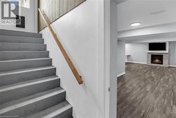 Stairs to separate suite with a warm lit fireplace and wood finished floors - 