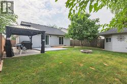 Fenced backyard featuring a fire pit, a patio, and a gazebo - 