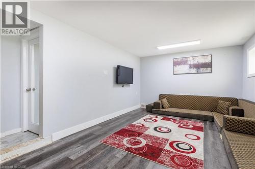 Spacious room featuring wood-finish flooring, light gray walls, and white baseboards - 18 Silverdale Crescent, London, ON - Indoor