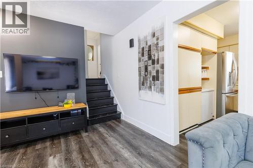 Wood-finish flooring throughout the living area, featuring a dark gray accent wall - 18 Silverdale Crescent, London, ON - Indoor