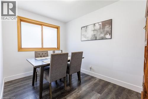 Dining area featuring a wood-frame window, dark wood-finish flooring, white walls, and bright baseboards - 18 Silverdale Crescent, London, ON - Indoor Photo Showing Dining Room