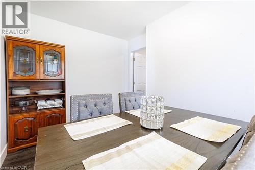 Dining area featuring dark wood-finish flooring, white walls, and a built-in wood-finish hutch with glass-front display cabinets - 18 Silverdale Crescent, London, ON - Indoor