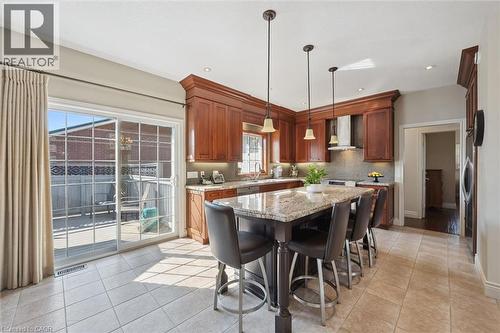 Kitchen featuring wood cabinetry, granite countertops, an integrated range hood, and tile flooring - 20 Bonniewood Drive, Drayton, ON - Indoor Photo Showing Other Room