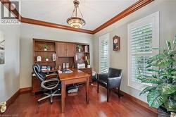 Dedicated office space featuring rich wood-finish flooring and custom built-in cabinetry - 