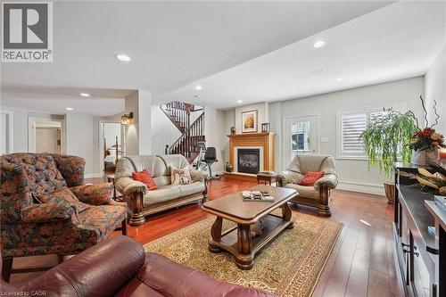 Spacious living area featuring wood-finish flooring, recessed lighting, and a fireplace with a wood mantle - 20 Bonniewood Drive, Drayton, ON - Indoor Photo Showing Living Room With Fireplace