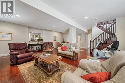 Spacious open-concept lower level featuring recessed lighting, rich wood-finish flooring, and a classic wooden staircase with balusters - 20 Bonniewood Drive, Drayton, ON - Indoor Photo Showing Living Room