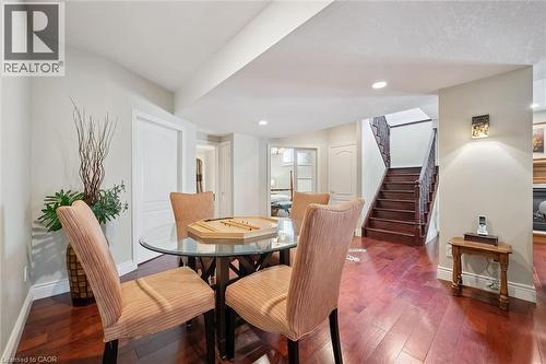 Hardwood flooring throughout featuring recessed lighting and a built-in staircase with dark wood banister - 20 Bonniewood Drive, Drayton, ON - Indoor Photo Showing Dining Room