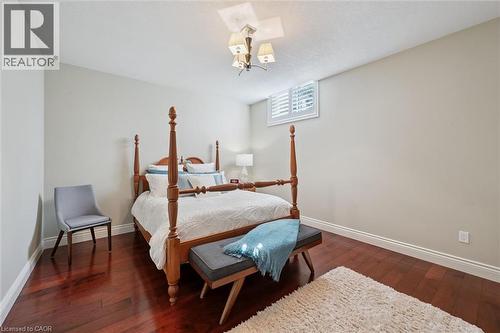 Rich wood-finish flooring complements the neutral wall tones - 20 Bonniewood Drive, Drayton, ON - Indoor Photo Showing Bedroom