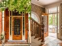 Brick facade with a substantial wood-finish entry door, featuring a decorative glass insert and sidelights - 95-97 S Fairholt Road S, Hamilton, ON  - Indoor Photo Showing Other Room 