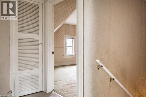 Interior room featuring a single window, sloped ceiling, and textured wallpaper - 95-97 S Fairholt Road S, Hamilton, ON - Indoor Photo Showing Other Room
