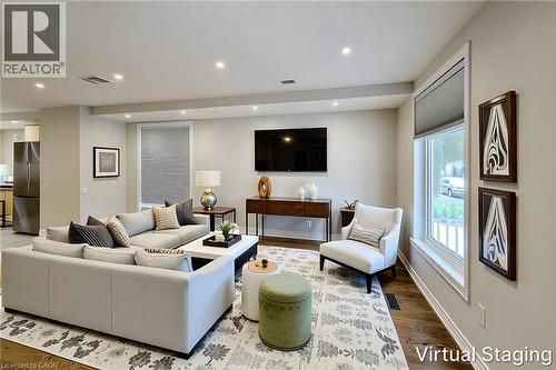 Open-concept living area featuring rich wood-finish flooring, recessed lighting, and ample natural light from multiple windows - 319 King Street W, Dundas, ON - Indoor Photo Showing Living Room