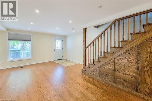 Hardwood flooring and recessed lighting illuminate this room, featuring a staircase with integrated storage - 319 King Street W, Dundas, ON - Indoor Photo Showing Other Room