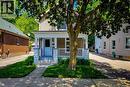 Front facade featuring a covered porch with white columns and railings, a light blue entry door, and a stucco finish on the upper level - 319 King Street W, Dundas, ON  - Outdoor With Deck Patio Veranda 