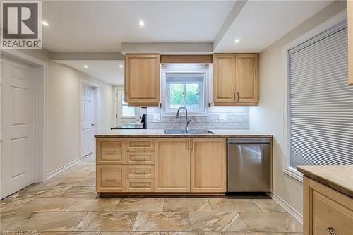Kitchen featuring natural wood-finish cabinetry, stainless steel dishwasher, undermount sink with a gooseneck faucet, light-toned countertop, and recessed ceiling lighting - 319 King Street W, Dundas, ON - Indoor Photo Showing Kitchen With Double Sink