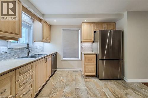 Kitchen featuring light wood cabinetry, stone-finish countertops, and a subway tile backsplash - 319 King Street W, Dundas, ON - Indoor Photo Showing Kitchen With Stainless Steel Kitchen With Double Sink