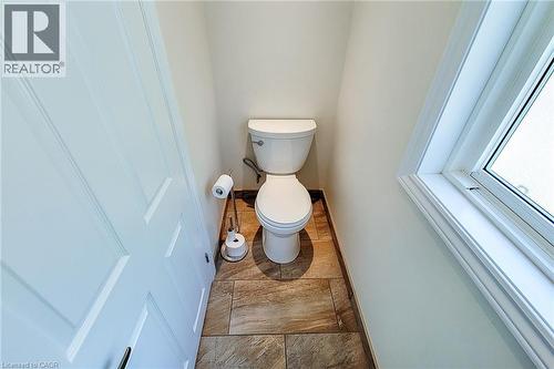 White toilet featuring a standard bowl, tank, and base - 319 King Street W, Dundas, ON - Indoor Photo Showing Bathroom