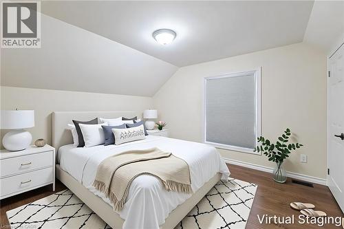Bedroom featuring rich wood-finish flooring, a contemporary window with cellular shades, and an angled ceiling line - 319 King Street W, Dundas, ON - Indoor Photo Showing Bedroom