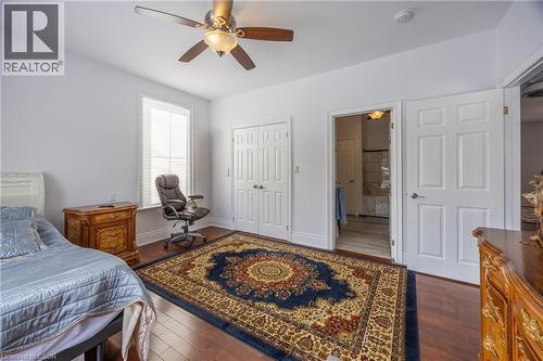 Bright interior space featuring wood-finish flooring, a ceiling fan with integrated lighting, and a window with blinds - 514 Fishers Glen Road, Vittoria, ON - Indoor Photo Showing Bedroom