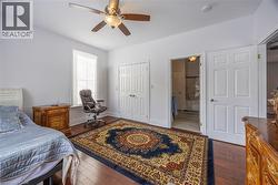 Bright interior space featuring wood-finish flooring, a ceiling fan with integrated lighting, and a window with blinds - 