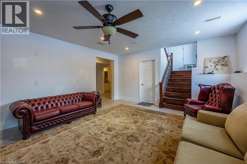 Spacious room featuring a wood-finish staircase, a ceiling fan with integrated lighting, and recessed ceiling lights - 514 Fishers Glen Road, Vittoria, ON - Indoor Photo Showing Living Room