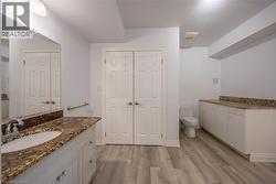 Bathroom featuring a wood-finish floor and white walls - 