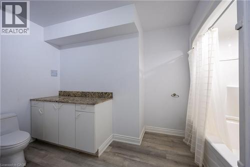Full bathroom featuring a white toilet, a shower-over-tub combination, and a vanity with a stone-finish countertop - 514 Fishers Glen Road, Vittoria, ON - Indoor Photo Showing Bathroom