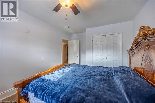 Bedroom featuring a ceiling fan with integrated lighting, white walls, and a paneled bifold closet door - 514 Fishers Glen Road, Vittoria, ON - Indoor Photo Showing Bedroom