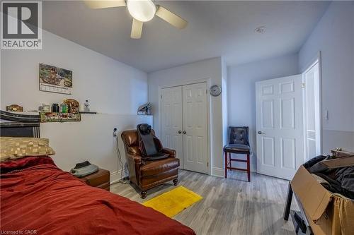 Bedroom featuring wood-finish flooring, a ceiling fan with integrated lighting, and white bi-fold closet doors - 514 Fishers Glen Road, Vittoria, ON - Indoor Photo Showing Bedroom
