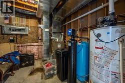 Utility room featuring a water heater, water treatment system, and electrical panel - 