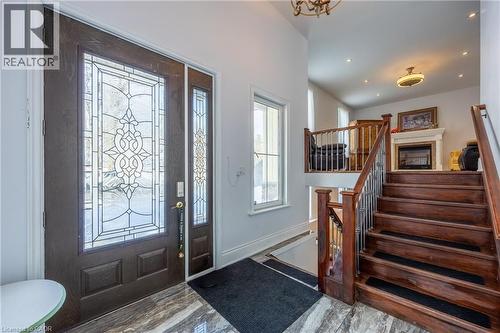 Entryway featuring a dark wood-finish door with decorative glass inserts, a matching sidelight, and marble-look flooring - 514 Fishers Glen Road, Vittoria, ON - Indoor Photo Showing Other Room