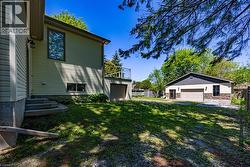 Detached garage featuring a double bay door and stone veneer accents - 