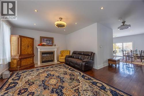 Living area featuring wood-finish flooring, a built-in fireplace with a stone surround, recessed lighting, and a ceiling fan - 514 Fishers Glen Road, Vittoria, ON - Indoor Photo Showing Living Room With Fireplace