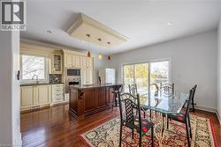 Kitchen and dining area featuring warm wood-finish flooring - 