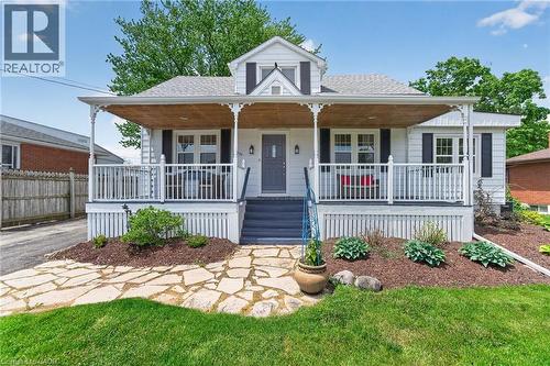 White siding exterior featuring a covered front porch with decorative balusters - 439 Murray Street, Grimsby, ON - Outdoor With Deck Patio Veranda