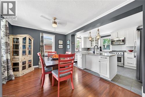Open-concept kitchen and dining area featuring a kitchen island, white cabinetry, stainless steel appliances - 439 Murray Street, Grimsby, ON - Indoor