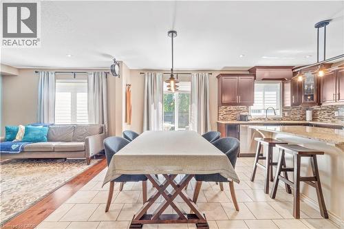 Open-concept dining and kitchen area with light-toned floor tiles - 21 Davinci Boulevard, Hamilton, ON - Indoor Photo Showing Dining Room