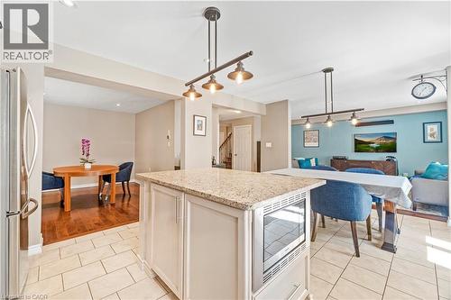 Kitchen island featuring a granite countertop and built-in microwave - 21 Davinci Boulevard, Hamilton, ON - Indoor Photo Showing Other Room