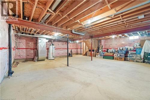 Expansive unfinished basement featuring a concrete floor, exposed wood ceiling joists, and a visible water heater - 21 Davinci Boulevard, Hamilton, ON - Indoor Photo Showing Basement